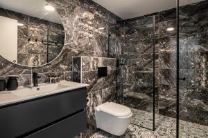 een badkamer met een toilet, een wastafel en een spiegel bij MACHNE YEHUDA - Exclusive Collection - By HOMY in Jeruzalem