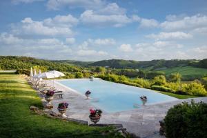 a swimming pool with a view of the hills at Laticastelli Country Relais in Rapolano Terme