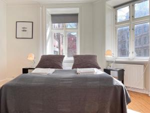 - une chambre blanche avec un grand lit et 2 fenêtres dans l'établissement Apartment Located In Cozy Area Of Copenhagen 2, à Copenhague