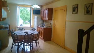 a kitchen with a table and chairs in a kitchen at Le gÎte andrÉ dhÔtel in Charbogne