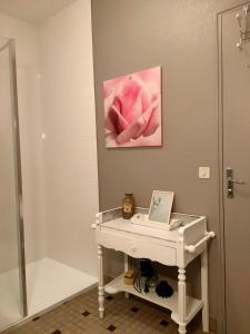 a bathroom with a white sink and a pink painting at Le gite andre dhotel 