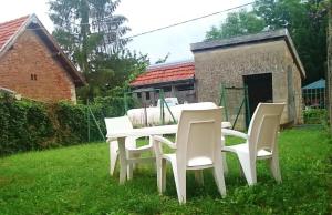 una mesa blanca y sillas en un patio en Le gite andre dhotel, 