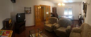 El Cortijo في Villalgordo del Jucar: غرفة معيشة مع كرسيين وتلفزيون