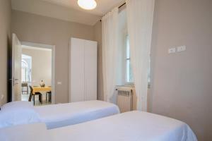 a bedroom with two beds and a table and a window at CasaSmeraldo in Rio Marina