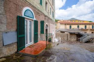 an old building with green shutters and a door at CasaSmeraldo in Rio Marina