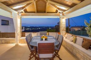 a dining room with a table and chairs on a patio at Villa Melissa by Estia in Hersonissos