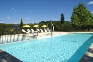 a large swimming pool with chairs and umbrellas at Maison Rose heerlijk ontspannen in luxe in Castelnaud La Chapelle