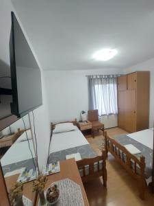a living room with two beds and a flat screen tv at Rooms Putnik in Senj