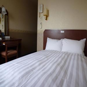 1 dormitorio con cama blanca, escritorio y espejo en Smile Hotel Nishi-Akashi, en Akashi