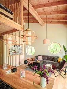 a living room with pendant lights and a couch at Lunette Lodge for 10 guests, 50 m from the lake, sauna, hot tube in Brzozie