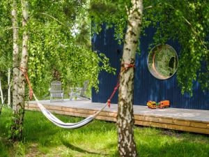 a hammock in the middle of a yard at Lunette Lodge for 10 guests, 50 m from the lake, sauna, hot tube in Brzozie