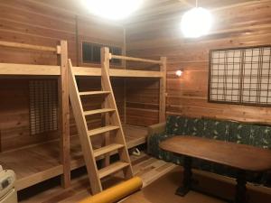 熊野市にある天女座エンタティメントゲストハウスの二段ベッド、ベンチ、はしごが備わる客室です。