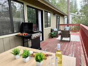 a patio with a table and a grill on a deck at Yosemite Expedition Chalet with bbq by Casa Oso in Oakhurst
