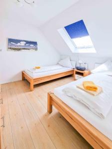 Dieses weiße Zimmer verfügt über 2 Betten und ein Dachfenster. in der Unterkunft De Möhlenkieker 4 in Greetsiel