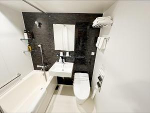 a bathroom with a toilet and a sink and a bath tub at HOTEL SUI AKASAKA by ABEST in Tokyo