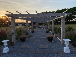 a wooden pergola in a garden with potted plants at Farmhouse Boutique in Ballyheigue