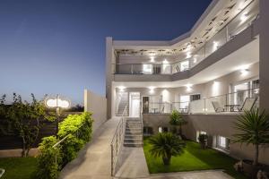 ein großes weißes Haus mit Treppen und Pflanzen in der Unterkunft Vice Hotel in Laganas