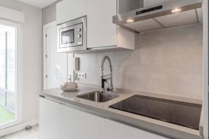a kitchen with a sink and a microwave at Apartamentos Recaredo 7, Áticos con terraza in Seville