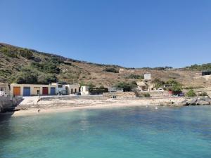 a beach with people swimming in the water at Bed and breakfast "Selena" with swim pool in Nadur