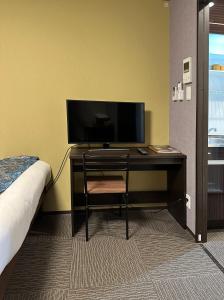 Schlafzimmer mit einem Schreibtisch, einem TV und einem Bett in der Unterkunft Miro京都二条城ホテル in Kyoto