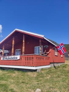 a woman holding a flag on the balcony of a house at Kyrkjestølen B&B in Tyinkrysset