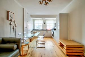 Pass the Keys Modern 3 Bed Flat on the Historic Royal Mile في إدنبرة: غرفة معيشة مع طاولة زجاجية ومطبخ