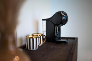 a coffee maker and two cups on a table at Lazy House Klaipeda in Klaipėda