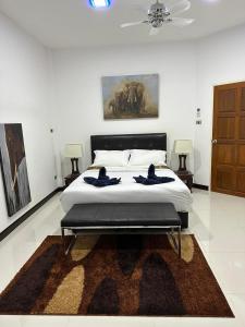 Villa Happy home في شاطئ راوايْ: غرفة نوم بسرير ودهان على الحائط