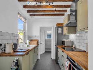 una cucina con armadi bianchi e piano di lavoro di Pass the Keys Large Terraced Home In the City a Canterbury