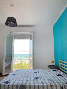 1 dormitorio con 1 cama y vistas al océano en Conero-30 mt dal Mare, Balcone V i s t a Mare e Spiaggia di sabbia en Porto Potenza Picena
