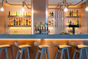 eine Bar mit vier Hockern vor einer Theke in der Unterkunft Ibis Styles Colmar Centre in Colmar