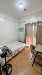 a bedroom with a bed and a desk and a chair at The Quiet pad in Manila