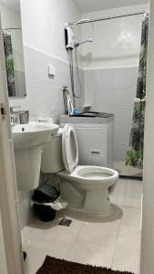 a bathroom with a white toilet and a sink at The Quiet pad in Manila