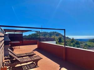 a balcony with benches and a view of the ocean at Cozy Apartament + BREAKFAST in La Esperanza