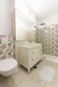 een witte badkamer met een toilet en een wastafel bij Eva in Boekarest