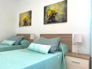 a bedroom with two beds and paintings on the wall at Cozy Apartament + BREAKFAST in La Esperanza