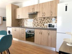 a kitchen with wooden cabinets and a white refrigerator at Cozy Apartament + BREAKFAST in La Esperanza