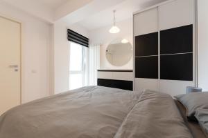 1 dormitorio con 1 cama grande y espejo en Eva en Bucarest