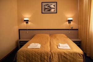 ein Schlafzimmer mit einem Bett mit zwei Handtüchern darauf in der Unterkunft Hotel Barentsburg in Barentsburg