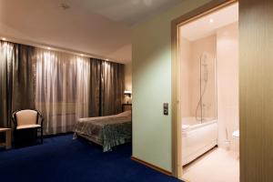 ein Hotelzimmer mit einem Bett und einer Badewanne in der Unterkunft Hotel Barentsburg in Barentsburg