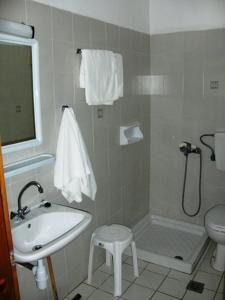 a bathroom with a sink and a toilet and a shower at Achillion Hotel in Skala Potamias