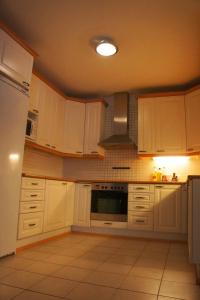 uma cozinha com armários brancos e um forno com placa de fogão em SweetDream Guesthouse em Helsínquia
