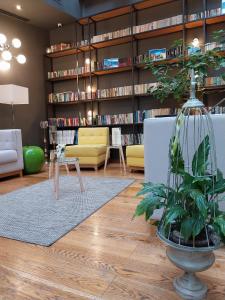 ein Wohnzimmer mit einer Bibliothek mit Bücherregalen in der Unterkunft Belfort Hotel in Braşov