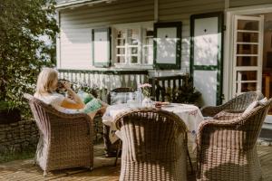 a woman sitting at a table talking on a cell phone at Willa Tyrolczyk in Karpacz