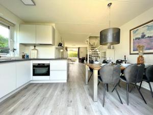 een keuken met witte kasten en een tafel en stoelen bij Vakantievilla Noordzee in Kamperland
