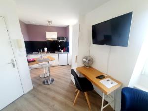 a small room with a desk and a kitchen at Concept Appar't Hôtel - 201 in Saint-Brieuc
