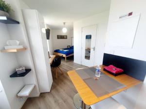 a small apartment with a table and a room at Concept Appar't Hôtel - 201 in Saint-Brieuc