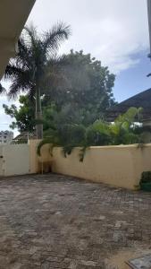 un mur avec des palmiers en arrière-plan dans l'établissement Crown Apartments, à Malindi