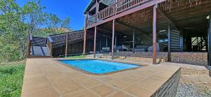 a swimming pool in front of a house at Loskop Serene Bush Cabin in Winterkamp
