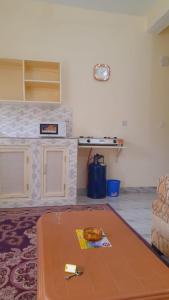 ein Wohnzimmer mit einem Tisch und einer Theke in der Unterkunft Crown Apartments in Malindi
